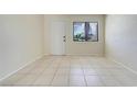 Bright living room featuring neutral tile floors, a large window, and a freshly painted white door at 1920 Dardanelle Dr, Orlando, FL 32808