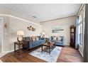 Inviting living room featuring wood floors, neutral tones, and large windows with a grandfather clock at 2085 Stone Cross Cir, Orlando, FL 32828