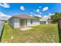 Spacious backyard with well-maintained lawn and a sliding door leading to a small patio area at 2110 Mallard Creek Cir, Kissimmee, FL 34743