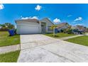 Front exterior view of home showing a two car garage, lawn, and sidewalk at 2110 Mallard Creek Cir, Kissimmee, FL 34743
