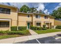 Townhouse exterior with a green front door, manicured shrubs, and a well-maintained lawn at 2208 Mcmahon Ct # 1033, Orlando, FL 32812