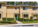 Townhouse exterior with a green front door, manicured shrubs, and a well-maintained lawn at 2208 Mcmahon Ct # 1033, Orlando, FL 32812