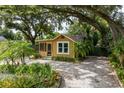 Charming cottage-style home with a screened porch and a brick driveway, surrounded by lush landscaping at 2320 E Crystal Lake Ave, Orlando, FL 32806