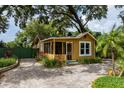 Charming cottage-style home with a screened porch and a brick driveway, surrounded by lush landscaping at 2320 E Crystal Lake Ave, Orlando, FL 32806