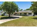 Charming one-story home with manicured lawn and mature trees, offering serene curb appeal with a concrete driveway at 2350 Derbyshire Rd, Maitland, FL 32751