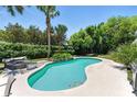 Inviting backyard featuring a kidney-shaped pool surrounded by lush greenery and a lounge area, perfect for relaxation at 2350 Derbyshire Rd, Maitland, FL 32751