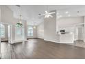 Open-concept living room with vaulted ceilings, wood floors, and views into the kitchen and foyer at 2675 Bond St, Clermont, FL 34711