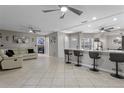 An open-concept living space features tile floors, ceiling fans, and a breakfast bar at 2936 Estill St, Deltona, FL 32738