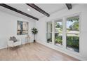 Bright living room featuring wood floors, a comfortable chair, and large windows overlooking the front yard at 3029 Pinetree, Winter Haven, FL 33884