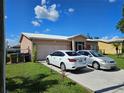 Beige single Gathering house with an attached garage and vehicles in the driveway at 306 Aylesbury Ct, Kissimmee, FL 34758