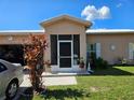 Welcoming front porch with a screen door and manicured landscaping at 306 Aylesbury Ct, Kissimmee, FL 34758