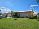Charming single-story home featuring a well-manicured lawn and lush landscaping at 306 Aylesbury Ct, Kissimmee, FL 34758