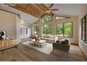 Living room with wood floors, high ceilings, wood beams, and a wall of windows overlooking the yard at 32125 Okaloosa Trl, Sorrento, FL 32776