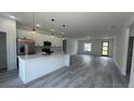 Modern kitchen boasts a spacious island, stainless steel appliances, and sleek pendant lighting at 482 Marion Oaks Mnr, Ocala, FL 34473
