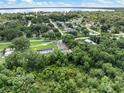 Aerial view of home nestled in a treed lot with nearby lake and residential community at 4925 Catfish Rd, Lake Wales, FL 33898