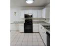 Functional kitchen with white cabinets, stainless steel appliances, granite countertops and tile flooring at 5396 Lonesome Dove Dr, Kissimmee, FL 34746