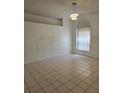 Bright living room with large window, modern chandelier, neutral paint, and tile flooring creating a versatile space at 5396 Lonesome Dove Dr, Kissimmee, FL 34746
