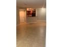 Spacious, empty living room, with tile floor and view of kitchen with breakfast bar at 5725 Gatlin Ave # 315, Orlando, FL 32822