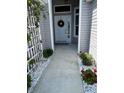 Inviting front entrance features a decorative wreath, lush greenery, and a tiled walkway at 862 Bowden Rd, Wildwood, FL 34785