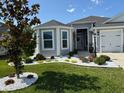 Charming single-story home with beautifully landscaped front yard, garden beds and a tree surrounded by decorative white stones at 862 Bowden Rd, Wildwood, FL 34785