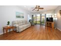 Bright living room with a ceiling fan, sliding glass doors and wood laminate flooring at 954 Courtyard Ln # 52, Orlando, FL 32825