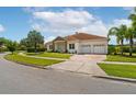 A view of the driveway, landscaping and well-maintained lawn in front of this house at 9821 Caroline Park Dr, Orlando, FL 32832