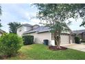 Single-story home showcasing manicured lawns, and a two-car garage at 13157 Paloma Dr, Orlando, FL 32837