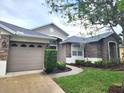 Charming single-story home showcasing stone accents, manicured garden beds, and a two-car garage at 13157 Paloma Dr, Orlando, FL 32837