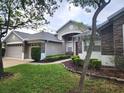 Charming single-story home showcasing stone accents, manicured garden beds, and a two-car garage at 13157 Paloma Dr, Orlando, FL 32837