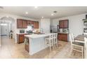 Open concept kitchen with an island, stainless steel appliances, and dark wood cabinets at 1010 Morvan Ln, Kissimmee, FL 34759