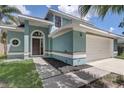 Charming light blue home with two car garage and well manicured lawn at 10599 Satinwood Cir, Orlando, FL 32825