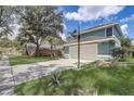 Exterior shot of the 2-car garage showing the driveway and partial yard and neighborhood view at 10599 Satinwood Cir, Orlando, FL 32825