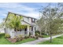 Inviting two-story home with a cozy front porch, complemented by lush landscaping and mature trees at 11139 Cyrilla Woods Dr, Orlando, FL 32832