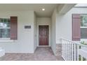 Inviting home entryway featuring brick pavers and a charming front door with dark brown shutters at 11139 Cyrilla Woods Dr, Orlando, FL 32832