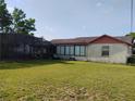 View of a grassy backyard featuring a screened-in enclosure at 1152 Ring St, Deltona, FL 32725