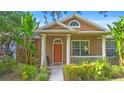 Inviting home featuring a charming front porch with columns and lush tropical landscaping at 12868 Holdenbury Ln, Windermere, FL 34786