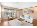Bright living room with a decorative beach theme, hardwood floors, large windows, and white couch at 12868 Holdenbury Ln, Windermere, FL 34786