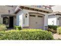 View of townhome garage with stone detail and manicured bushes at 14088 Tarvin St, Orlando, FL 32832