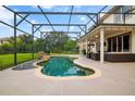 Backyard oasis featuring a screened-in pool, stone waterfall, and covered patio area at 2507 Water Valley Dr, St Cloud, FL 34771