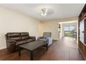 Open living room with a brown leather couch, a gray armchair, and sliding doors to a balcony at 2791 L B Mcleod Rd # C, Orlando, FL 32805