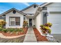 Close-up of front entryway with colorful plants, mulched beds and a walkway at 280 Bay St, Apopka, FL 32712