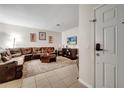Comfortable living room with a large brown sectional sofa, a TV, and light-colored tile flooring at 2820 Oakwater Dr # 2820, Kissimmee, FL 34747