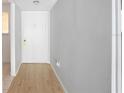 Clean hallway with wood-look floors and neutral paint, leading to the front door at 2850 N Powers Dr # 74, Orlando, FL 32818