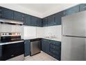 Modern kitchen featuring stainless steel appliances, navy cabinets and white subway tile backsplash at 2850 N Powers Dr # 74, Orlando, FL 32818