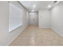 Clean living room featuring tile floors, white walls, and ample natural light from a large window at 326 Charles Dr, Deland, FL 32724