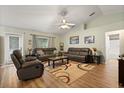 Bright living room boasts vaulted ceilings, wood-look flooring, and comfortable leather seating arrangement at 3610 Doe Run Dr, St Cloud, FL 34772