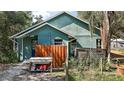 A view of the side of a charming home with a wooden fence and lush foliage at 42108 Pine Valley Dr, Paisley, FL 32767