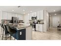 Modern kitchen featuring white cabinets, stainless steel appliances, and a large center island with seating at 4693 Golden Knight Blvd, Kissimmee, FL 34746