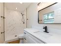 Bathroom featuring modern fixtures, including a sleek vanity and a shower with marble-like tile at 5021 Saint Marie Ave, Belle Isle, FL 32812