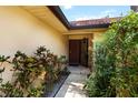 Inviting front entrance adorned with lush greenery, featuring a security screen door and warm, welcoming ambiance at 5057 Maui Cir # 15, Orlando, FL 32808